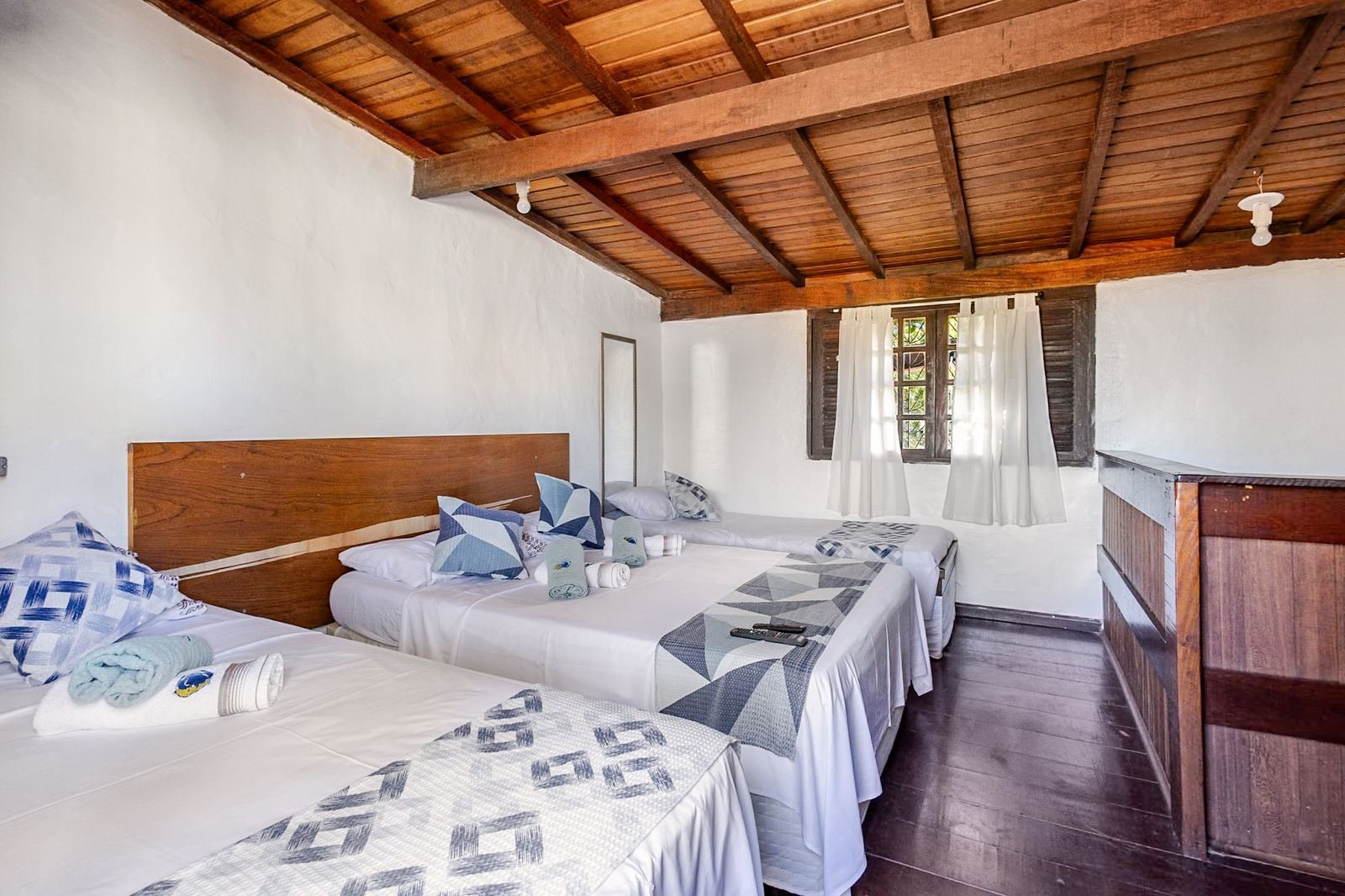Quarto do mezanino com camas e roupa de cama azul