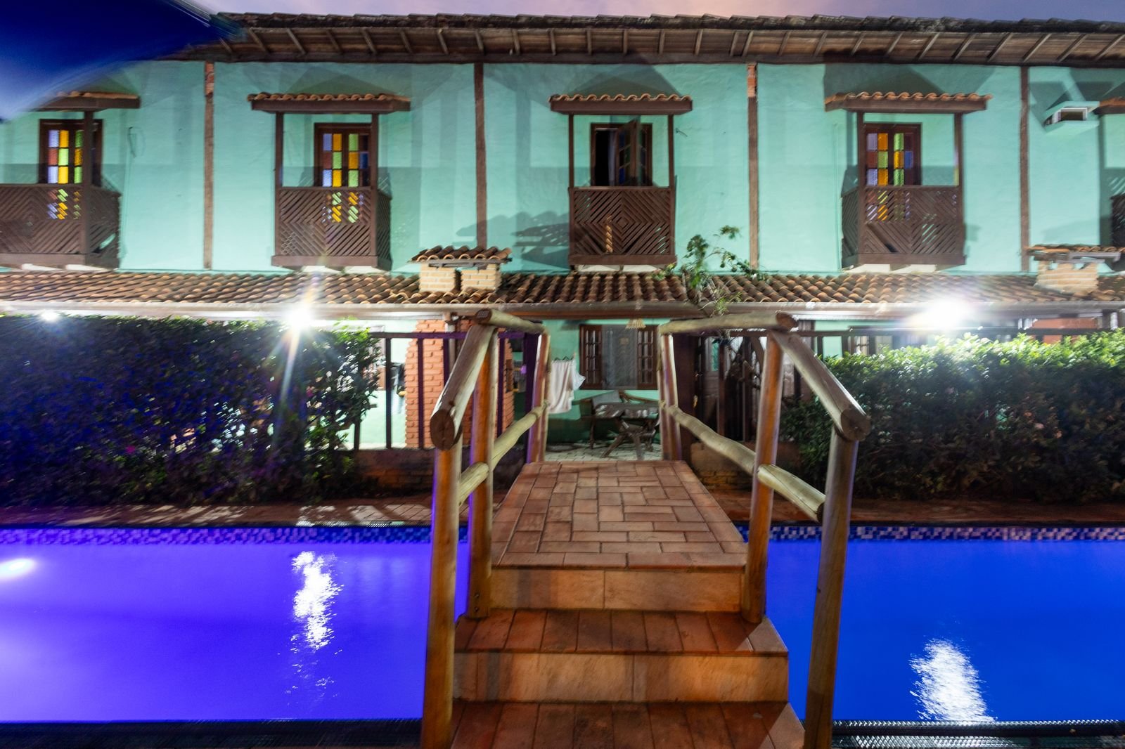 Passarela de acesso à piscina, cercada por vegetação